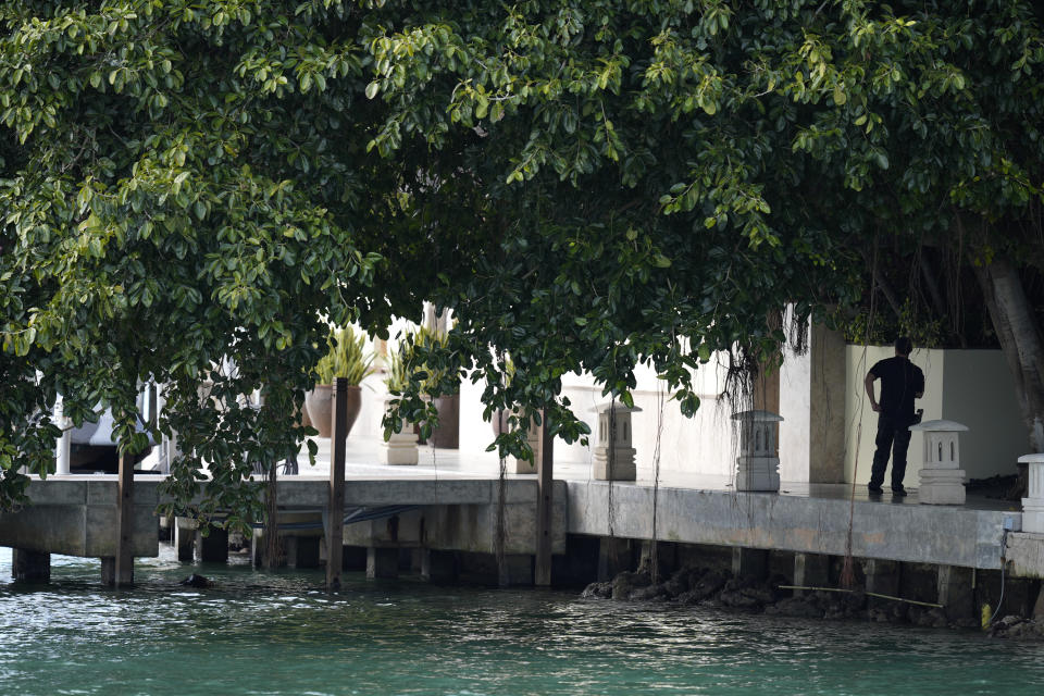 A law enforcement agent stands watch at the edge of a property belonging to rapper Sean "Diddy" Combs, as it is searched by federal agents, Monday, March 25, 2024, on Star Island in Miami Beach, Fla. Two properties belonging to Combs in Los Angeles and Miami were searched by federal Homeland Security Investigations agents and other law enforcement as part of an ongoing sex trafficking investigation by federal authorities in New York, two officials told The Associated Press. (AP Photo/Rebecca Blackwell)