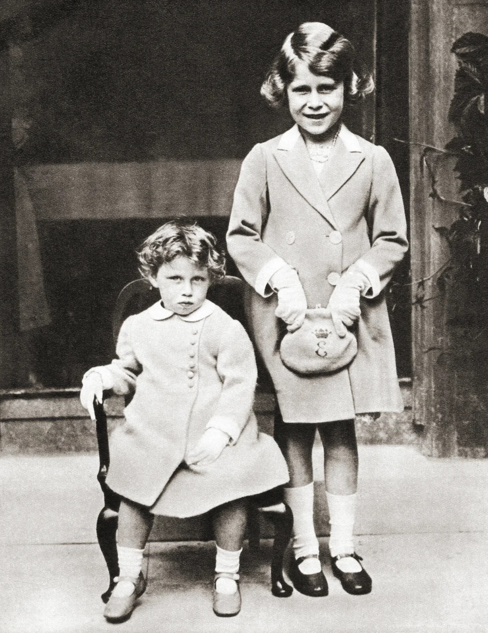 <p>Princess Elizabeth of York and her younger sister Princess Margaret with gifts presented to them by members of the Disabled Soldier's Embroidery Society in 1933. (Getty Images)</p> 