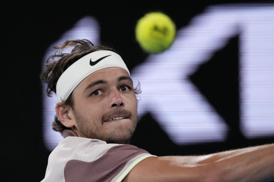 Taylor Fritz of the U.S. plays a backhand return to Stefanos Tsitsipas of Greece during their fourth round match at the Australian Open tennis championships at Melbourne Park, Melbourne, Australia, Sunday, Jan. 21, 2024. (AP Photo/Alessandra Tarantino)
