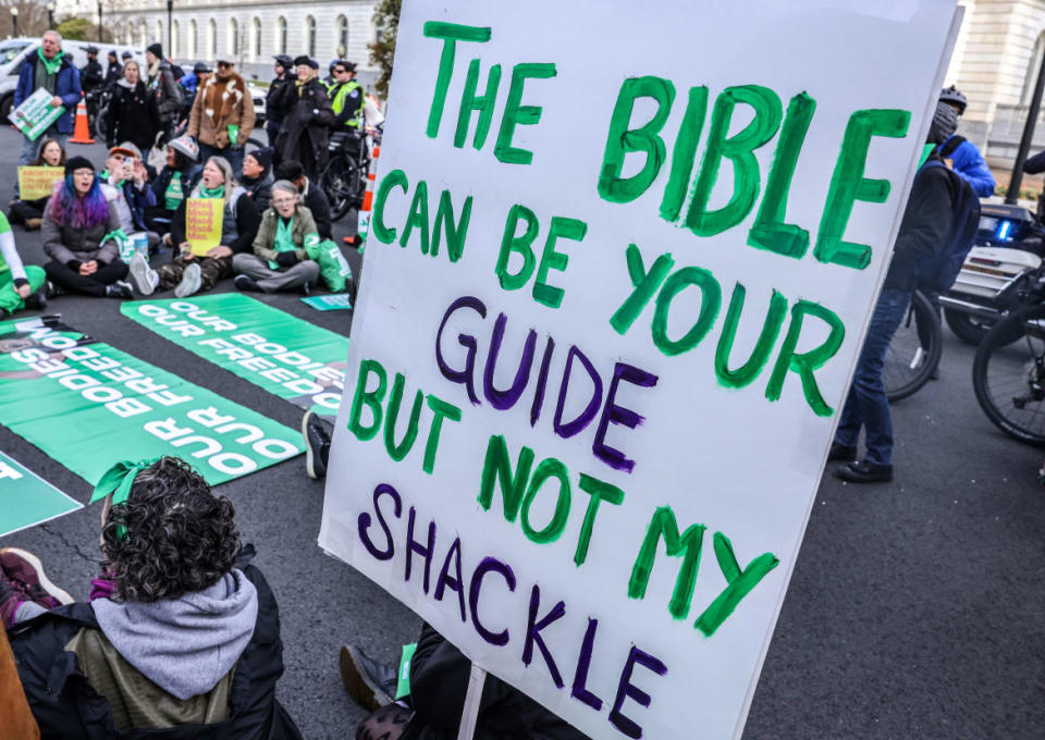 Photograph of people protesting outside the Supreme Court when they are hearing a case about mifeprestone used for abortions