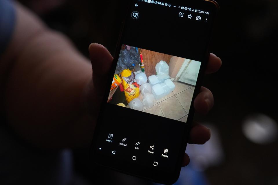 Pam Wiedman shows a photo of water she had to buy when her water was cut off at their home in Mesa.