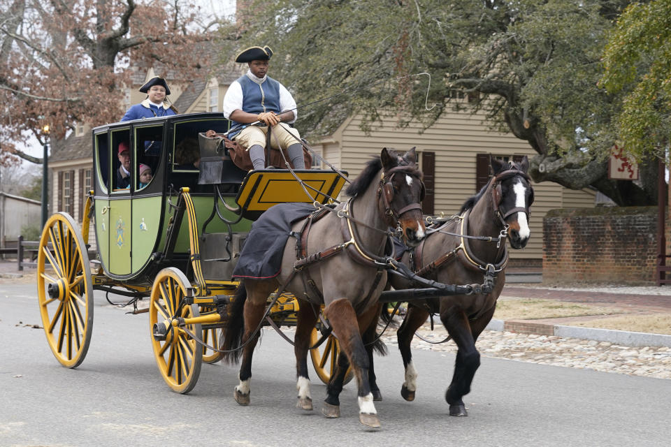 Colonial Williamsburg coachman Collin Ashe drives a coach full of visitors down Duke of Gloucester Street in the restored area Thursday Feb. 24, 2022, in Williamsburg, Va. Colonial Williamsburg has begun to honor the coachmen by naming a new carriage after one of them. (AP Photo/Steve Helber)