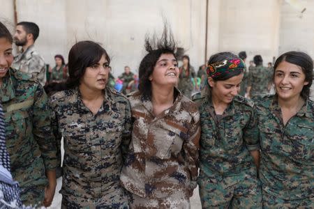 Syrian Democratic Forces (SDF) female fighters dance during a graduation ceremony in the city of Hasaka, northeastern Syria, August 9, 2017. REUTERS/Rodi Said