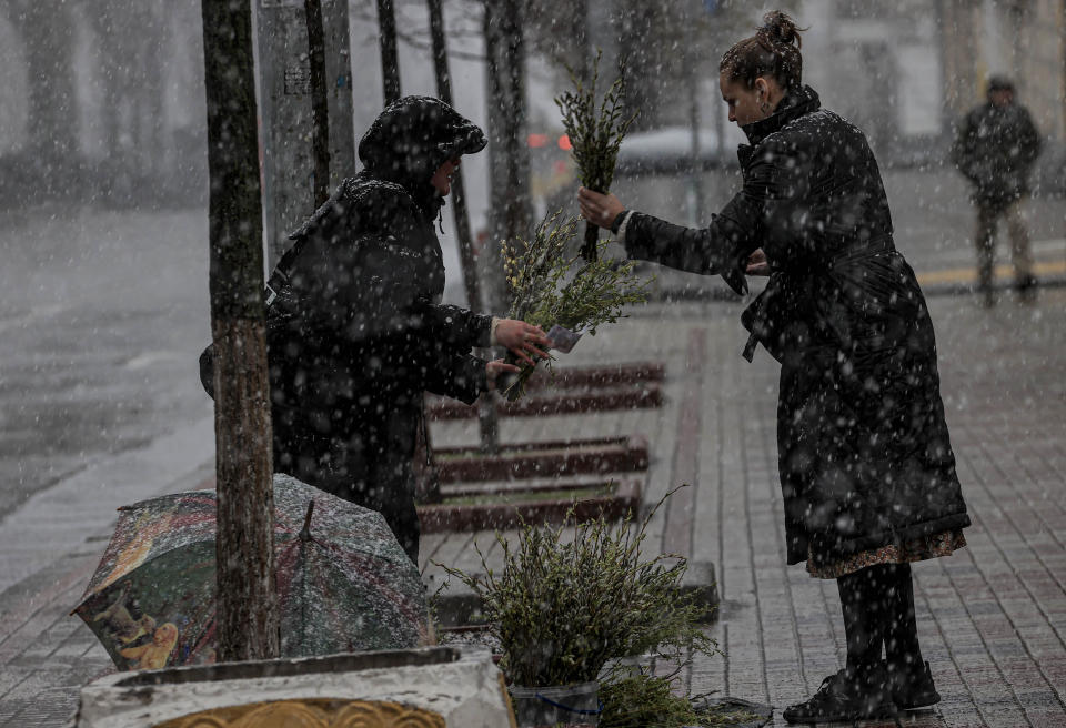 A woman buys tree branches prior to Palm Sunday mass.