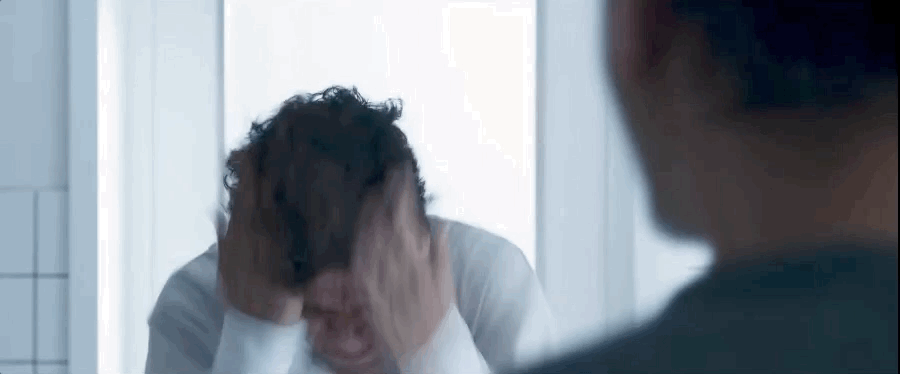 A gif of Oscar Isaac pulling at his hair and face during a manic moment on Moon Knight