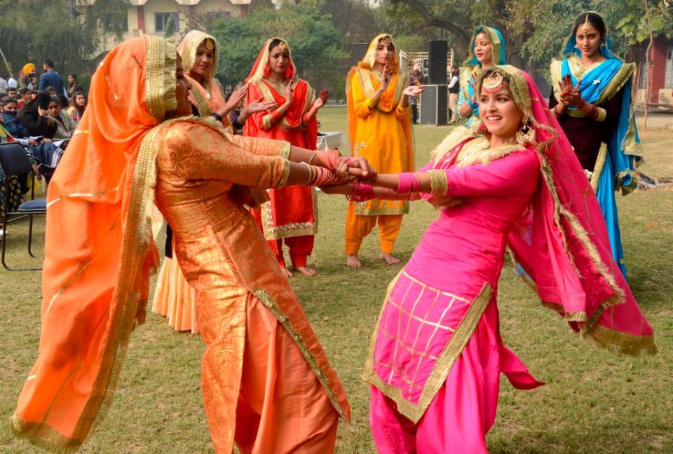 Students wearing traditional Punjabi outfits perform a folk dance to celebrate Lohri (AFP via Getty Images)