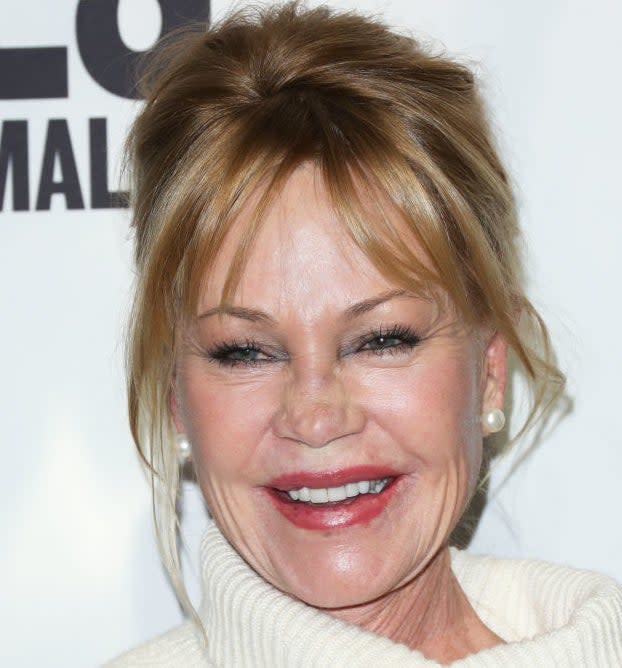 Melanie Griffith smiling at an event in  turtleneck