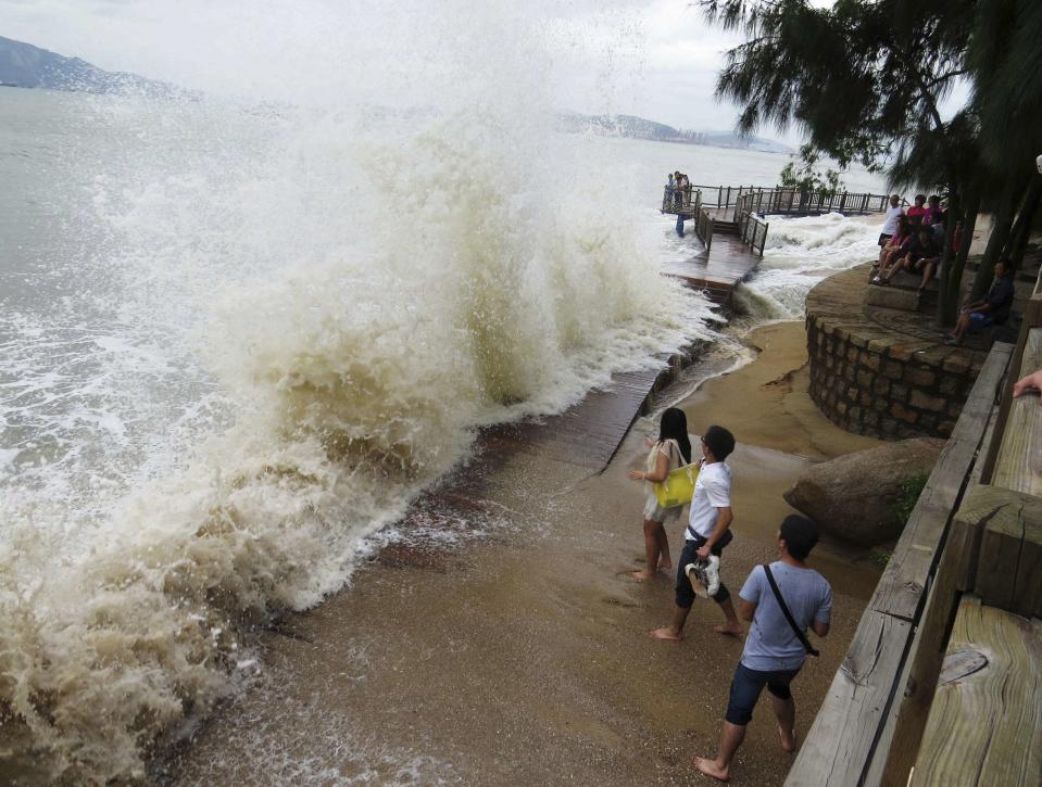 People watch as a storm surge hits the shores as Typhoon Usagi approaches Xiamen, Fujian province, September 21, 2013. According to official Xinhua news agency, China's National Meteorological Center issued its highest alert, warning that Usagi would bring gales and downpours to southern coastal areas. More than 80,000 people had moved to safety in Fujian province and authorities had deployed at least 50,000 disaster-relief workers. Picture taken September 21, 2013. REUTERS/Stringer (CHINA - Tags: ENVIRONMENT TPX IMAGES OF THE DAY) CHINA OUT. NO COMMERCIAL OR EDITORIAL SALES IN CHINA