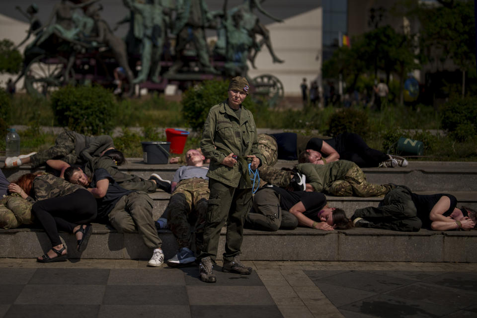 Ukrainian refugees, one impersonating a Russian soldier, other playing roles of Ukrainian war prisoners, perform during an event in Bucharest, Romania, Saturday, April 13, 2024. Members of the Ukrainian refugee community staged an event dubbed "Voices of Captives" to raise awareness to the plight of Ukrainian servicemen and civilians still in Russian custody. (AP Photo/Vadim Ghirda)