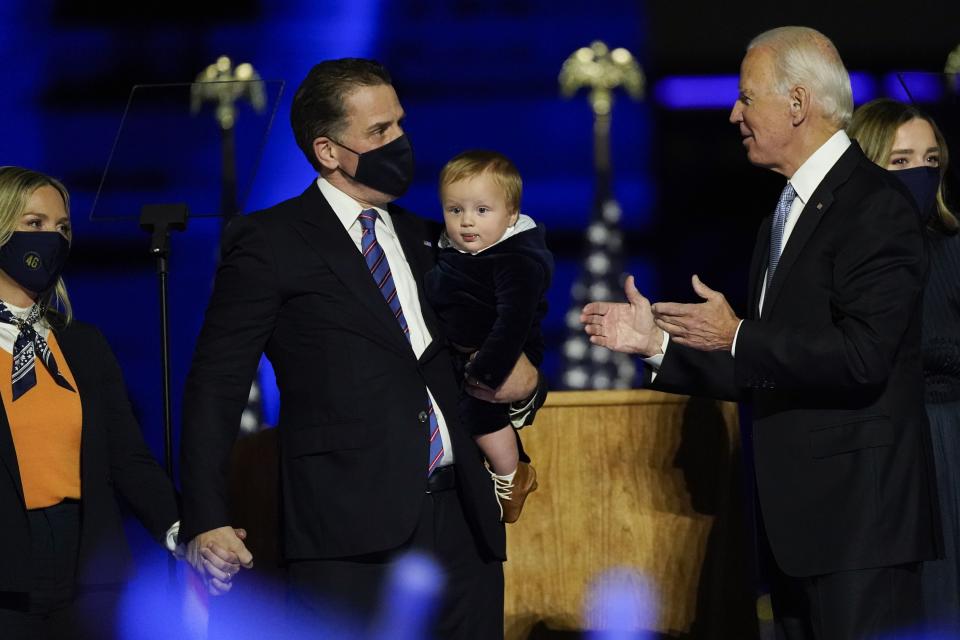 President-elect Joe Biden greets his son Hunter Biden and wife Melissa Cohen, left, as he holds his son, as he stands on stage with his family Saturday, Nov. 7, 2020, in Wilmington, Del.