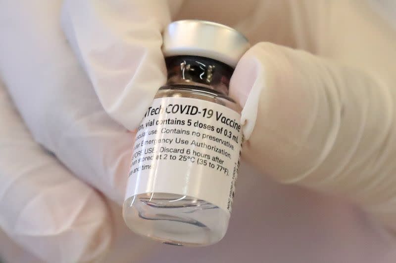 FILE PHOTO: A healthcare worker holds a coronavirus disease (COVID-19) vaccine vial at Martin Luther King Jr. Community Hospital, in South Los Angeles