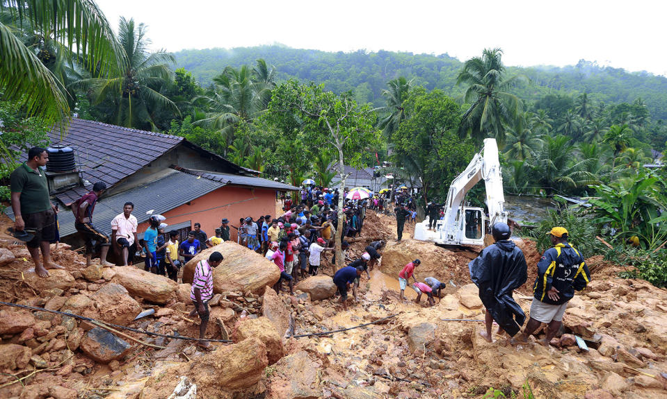 <p>Sri Lankans watch military rescue efforts at the site of a landslide at Bellana village in Kalutara district, Sri Lanka, May 26, 2017. Mudslides and floods triggered by heavy rains in Sri Lanka killed dozens and left many more missing on Friday. (Photo: Eranga Jayawardena/AP) </p>