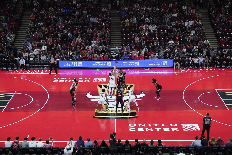 The Brooklyn Nets, left, and the Chicago Bulls tip off on a court designed for their NBA in-season tournament basketball game Friday, Nov. 3, 2023, in Chicago. (AP Photo/Charles Rex Arbogast)