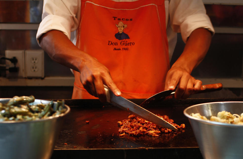 Taquero corta carne de puerco en un puesto de comida callejera en Ciudad de México. REUTERS/Tomas Bravo.