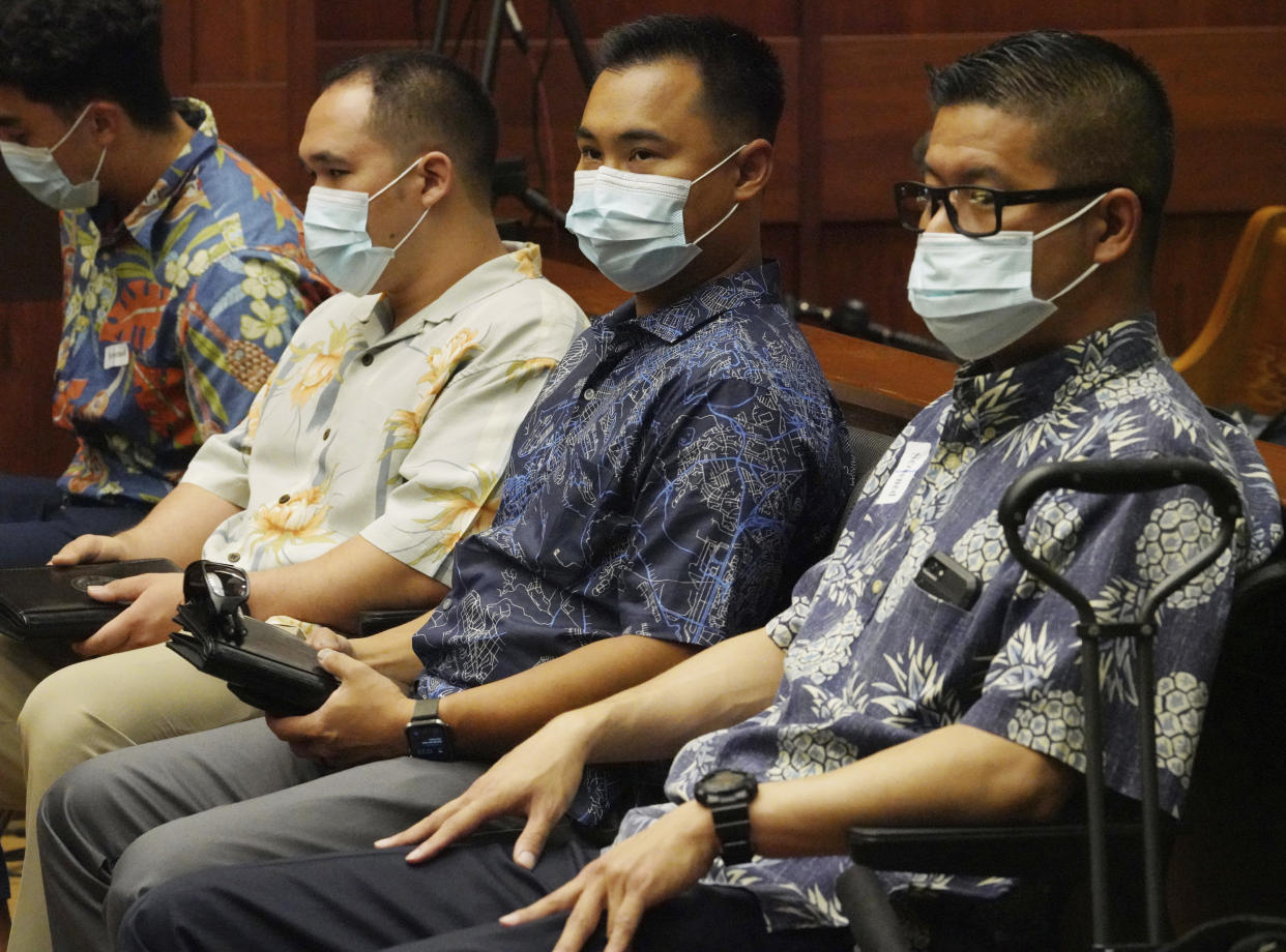 FILLE - Honolulu Police Officers Geoffrey Thom, right, Christopher Fredeluces, second from right, and Zackary Ah Nee, third from right, sit in Judge William Domingo's courtroom before a preliminary hearing begins, Tuesday, July 20, 2021, in Honolulu. Domingo on Wednesday, Aug. 18 rejected murder and attempted murder charges against the three officers in the fatal shooting of a teenager, preventing the case from going to trial. (Cory Lum/Honolulu Civil Beat via AP, Pool, File)