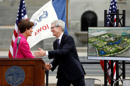 Apple Chief Executive Officer Tim Cook shakes hands with Iowa Gov. Kim Reynolds before discussing Apple plans to build a $1.375 billion data center in Waukee, Iowa, at the Iowa State Capitol in Des Moines, Iowa August 24, 2017. REUTERS/Scott Morgan