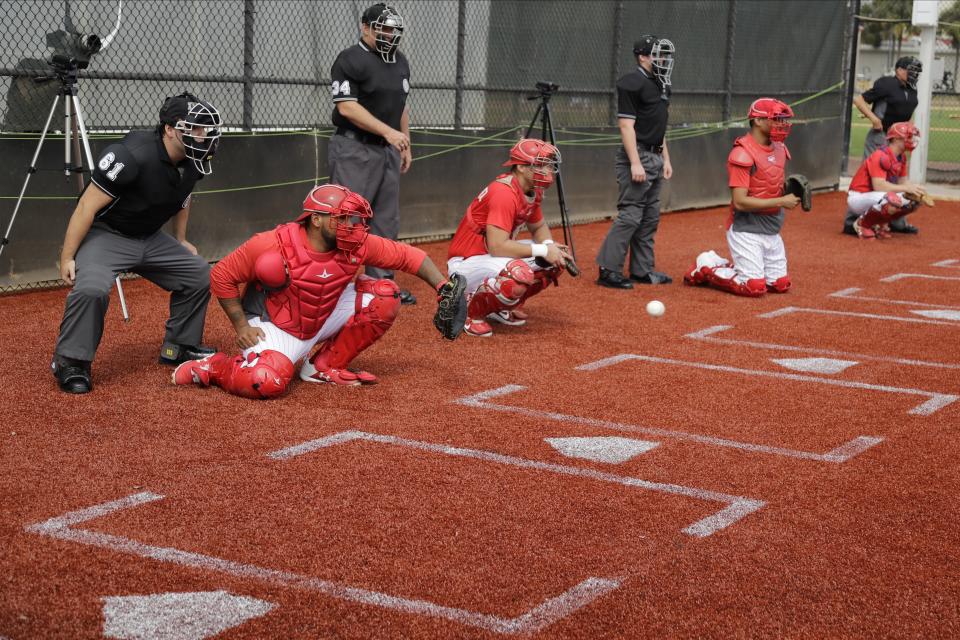 Philadelphia Phillies catchers work in the bullpen during a spring training baseball workout Friday, Feb. 14, 2020, in Clearwater, Fla. (AP Photo/Frank Franklin II)