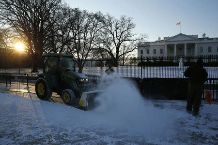 Workers plow snow from the sidewalk in front of the White House in Washington January 21, 2016. REUTERS/Jonathan Ernst