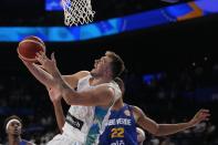 Slovenia guard Luka Doncic (77) tries to shoot against Cape Verde center Edy Tavares (22) in the second half of their Basketball World Cup group F match in Okinawa, southern Japan, Wednesday, Aug. 30, 2023. (AP Photo/Hiro Komae)