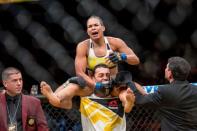 Jul 9, 2016; Las Vegas, NV, USA; Amanda Nunes (blue gloves) reacts after defeating Miesha Tate (red gloves) during UFC 200 at T-Mobile Arena. Nunez won by rear naked choke. Mandatory Credit: Joshua Dahl-USA TODAY Sports