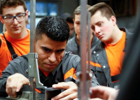 Qudratullah Hotak, a 25-year-old refugee from Afghanistan and one of 24 trainees of Ford Germany's so-called Equipment Qualification (EQ) program to integrate migrants in a booming labour market, is pictured among German trainees at the training workshop of Ford Motor Co in Cologne, Germany, January 11, 2019. Picture taken January 11, 2019. REUTERS/Wolfgang Rattay