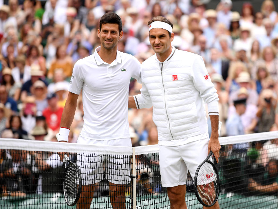 Novak Djokovic and Roger Federer pose for a photo at the net prior to their Men's Singles final on day thirteen of the Wimbledon Championships at the All England Lawn Tennis and Croquet Club, Wimbledon.