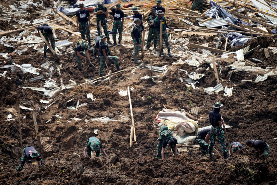 Rescuers search for victims of an earthquake-triggered landslide in Cianjur, West Java, Indonesia, Wednesday, Nov. 23, 2022. More rescuers and volunteers were deployed Wednesday in devastated areas on Indonesia's main island of Java to search for the dead and missing from an earthquake that killed hundreds of people. (AP Photo/Tatan Syuflana)