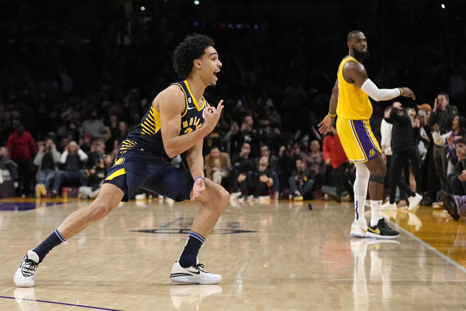 Indiana Pacers guard Andrew Nembhard, left, celebrates after making a buzzer beating 3-point shot to win the game as Los Angeles Lakers forward LeBron James stands in the background during the second half of an NBA basketball game Monday, Nov. 28, 2022, in Los Angeles. The Pacers won 116-115. (AP Photo/Mark J. Terrill)