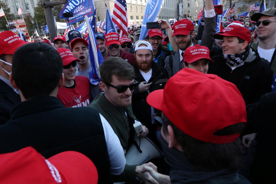 Nick Fuentes makes his way through a crowd of people wearing Make American Great Again hats