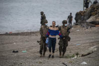 A man from Morocco is detained by soldiers of the Spanish Army at the border of Morocco and Spain, at the Spanish enclave of Ceuta, on Tuesday, May 18, 2021. Ceuta, a Spanish city of 85,000 in northern Africa, faces a humanitarian crisis after thousands of Moroccans took advantage of relaxed border control in their country to swim or paddle in inflatable boats into European soil. Around 6,000 people had crossed by Tuesday morning since the first arrivals began in the early hours of Monday, including 1,500 who are presumed to be teenagers. (AP Photo/Javier Fergo)