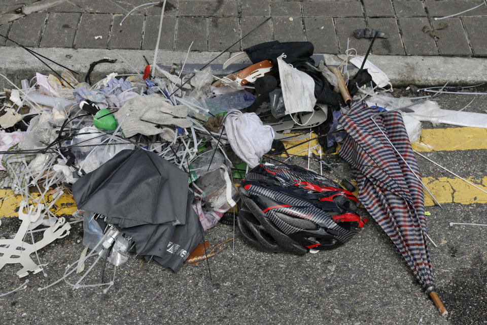 In this Friday, June 14, 2019, photo, broken umbrellas left in the aftermath of Wednesday's violent protest against proposed amendments to an extradition law are seen in Hong Kong. Umbrellas became a symbol of protest in Hong Kong in 2014 after demonstrators used them to shield themselves from both police pepper spray and a hot sun. Five years later, umbrellas were out in force again on Wednesday as thousands of protesters faced off with police outside the legislature. (AP Photo/Vincent Yu)