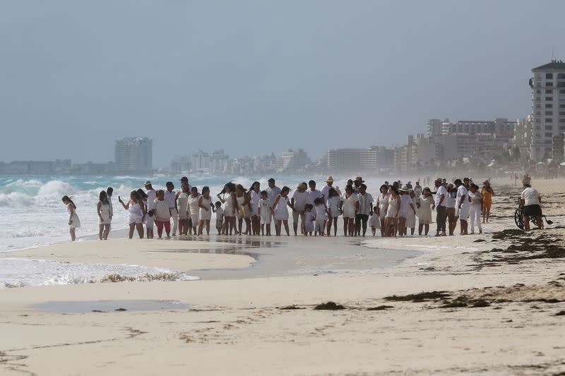 Members of a religious group gather at the beach as Hurricane Zeta approaches Cancun