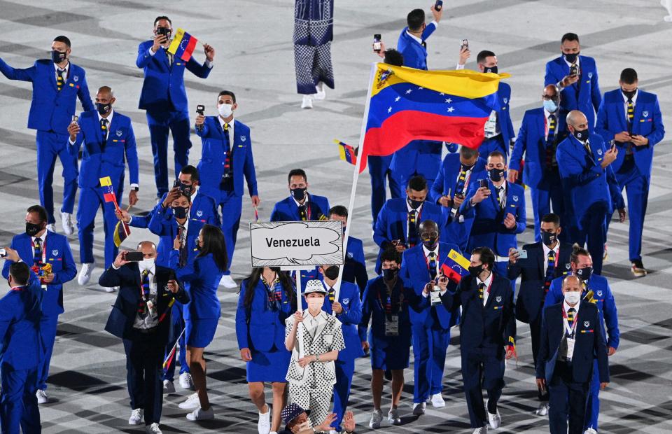 <p>Venezuela's flag bearer Karen Leon and Venezuela's flag bearer Antonio Jose Diaz Fernandez leads the delegation during the opening ceremony of the Tokyo 2020 Olympic Games, at the Olympic Stadium, in Tokyo, on July 23, 2021. (Photo by Martin BUREAU / AFP) (Photo by MARTIN BUREAU/AFP via Getty Images)</p> 
