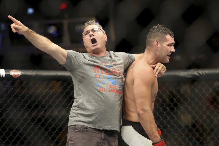 Charlie Weidman (L), embraces his son, former UFC middleweight champion Chris Weidman, after Chris submitted Kelvin Gastelum Saturday. (The Associated Press)