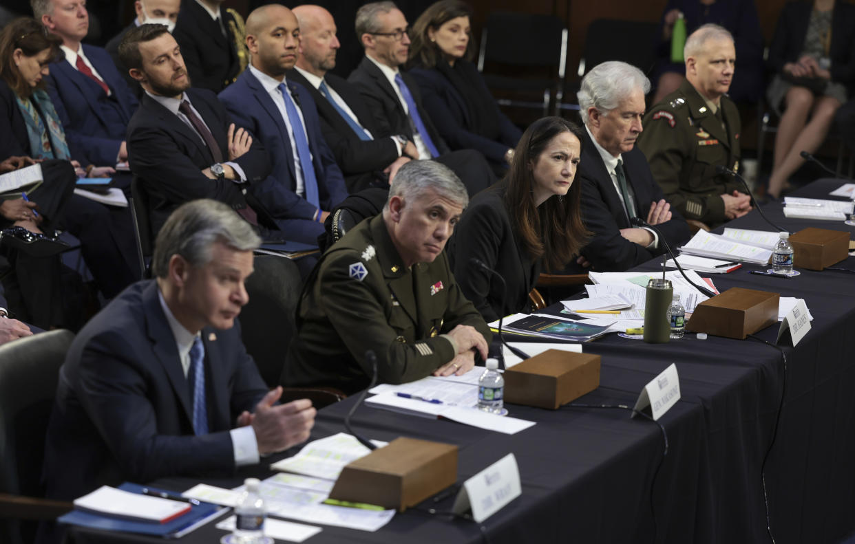 A row of five officials seated with microphones wait for questions in Congress, as aides stand behind them.