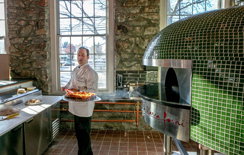 Chef Andy McWilliams pulls out a pizza at Brick Pizza Co. in Bristol which will open later in January.