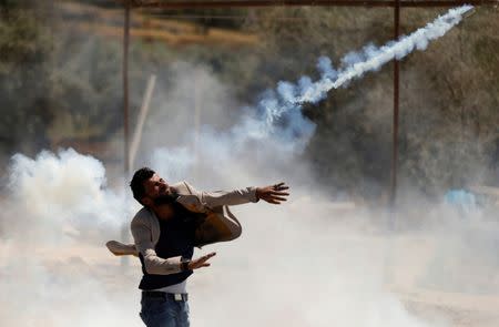 A Palestinian protester hurls back a tear gas canister fired by Israeli troops during clashes in the West Bank village of Beita, near Nablus May 12, 2017. REUTERS/Mohamad Torokman