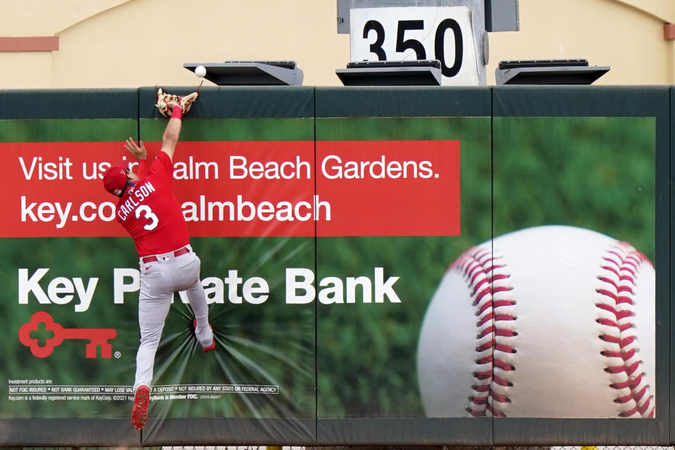 St. Louis Cardinals left fielder Dylan Carlson (3) cannot get to a ball hit by Miami Marlins' Peyton Burdick for a solo home run during the fifth inning of a spring training baseball game, Monday, March 22, 2021, in Jupiter, Fla. (AP Photo/Lynne Sladky)