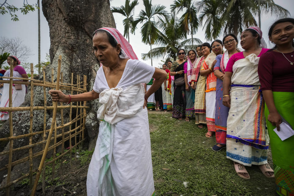 An elederly Deori tribal woman arrives as others of her tribe stand in a queue to cast their vote during the first round of polling of India's national election in Jorhat, India, Friday, April 19, 2024. Nearly 970 million voters will elect 543 members for the lower house of Parliament for five years, during staggered elections that will run until June 1. (AP Photo/Anupam Nath)