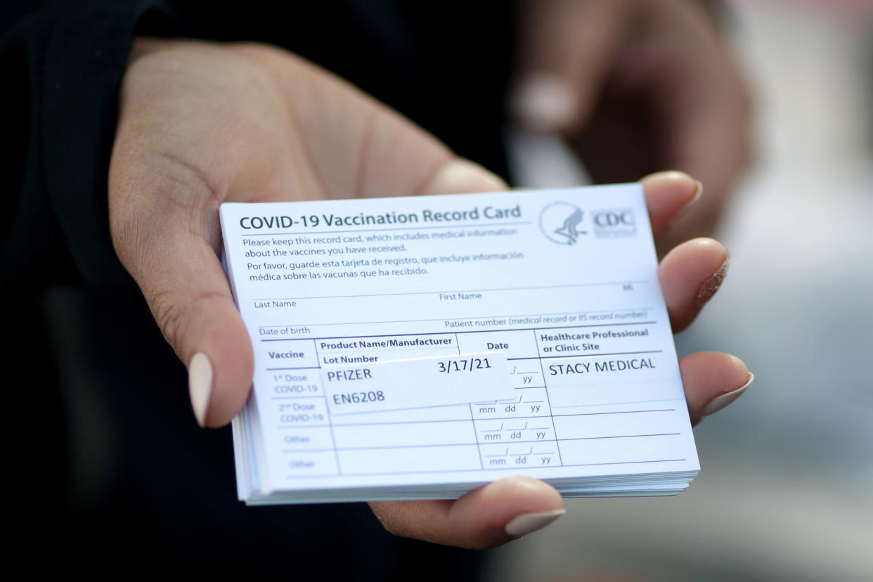 A medical worker holds Pfizer coronavirus disease (COVID-19) vaccination cards at a mobile vaccination drive for essential food processing workers at Rose & Shore, Inc., in Vernon, Los Angeles, California, U.S., March 17, 2021. REUTERS/Lucy Nicholson