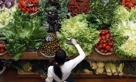 An employee arranges pricetags at a vegetables work bench during the opening day of upmarket Italian food hall chain Eataly's flagship store in downtown Milan, March 18, 2014. REUTERS/Alessandro Garofalo