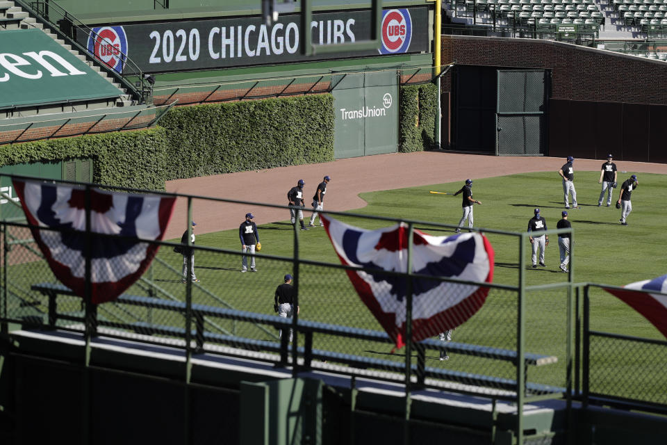 Milwaukee Brewers players warm up before an opening day baseball game against the Chicago Cubs in Chicago, Friday, July 24, 2020, in Chicago. In a normal year, that would mean a sellout crowd at Wrigley Field and jammed bars surrounding the famed ballpark but in a pandemic-shortened season, it figures to be a different atmosphere. (AP Photo/Nam Y. Huh)