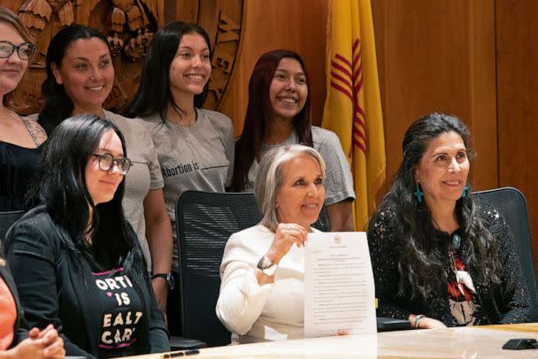 PHOTO: Gov. Michelle Lujan Grisham, center holds the Executive Order to protect access to Abortion in New Mexico after a signing ceremony on June 27, 2022, in Albuquerque, N.M. At right is Senator Linda Lopez.  (Adolphe Pierre-Louis/Albuquerque Journal via ZUMA Press Wire)