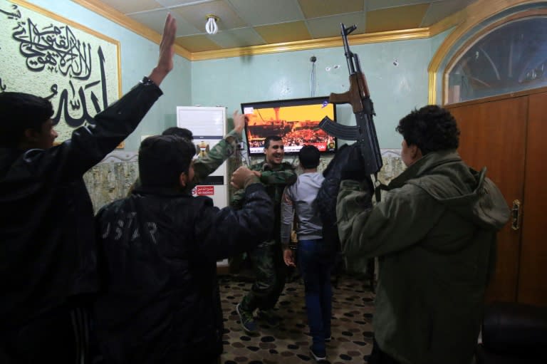 Members of the Hashed al-Shaabi (Popular Mobilisation units) watch Iraqi Prime Minister Haider al-Abadi declare victory in the three-year war to expel the Islamic State group that at its height held one third of Iraq's territory