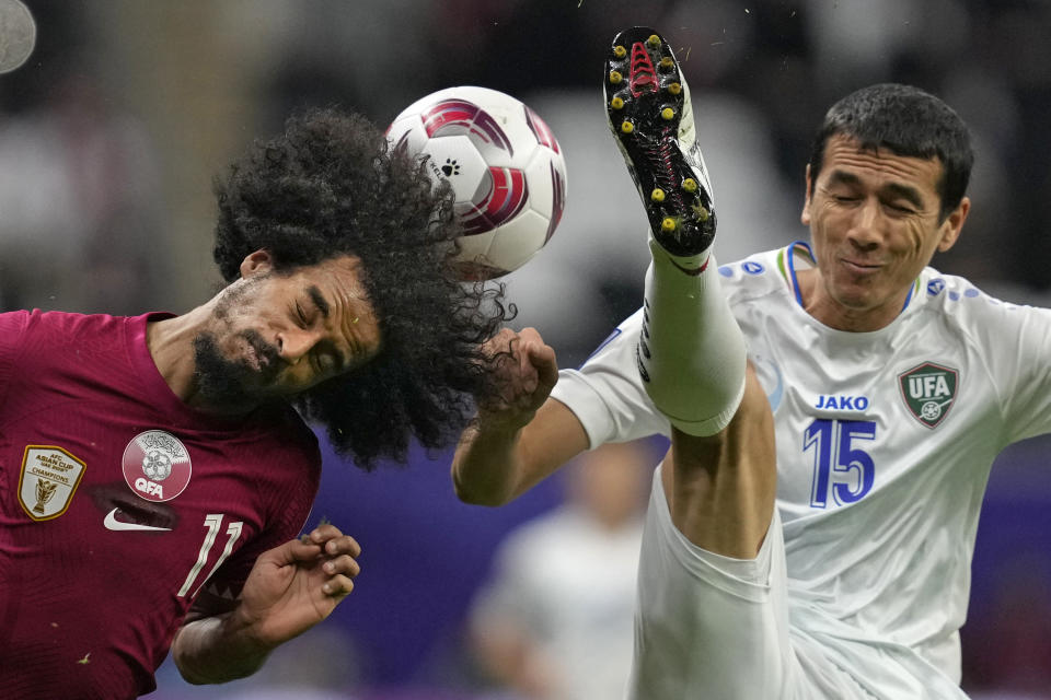 Qatar's Akram Afif, left, and Uzbekistan's Eshmurodov Umarbek fight for the ball during the quarterfinal soccer match between Qatar and Uzbekistan at Al Bayt stadium in Al Khor, Qatar, Saturday, Feb. 3, 2024. (AP Photo/Thanassis Stavrakis)