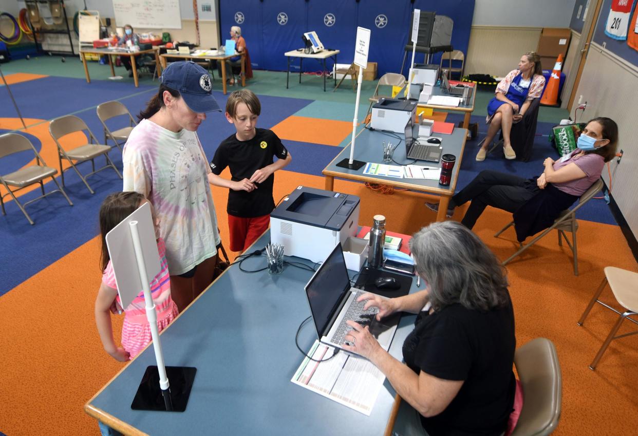 Voters check in at Forest Hills Elementary School to participate in the primary election in Wilmington, N.C., Tuesday, May 17, 2022.