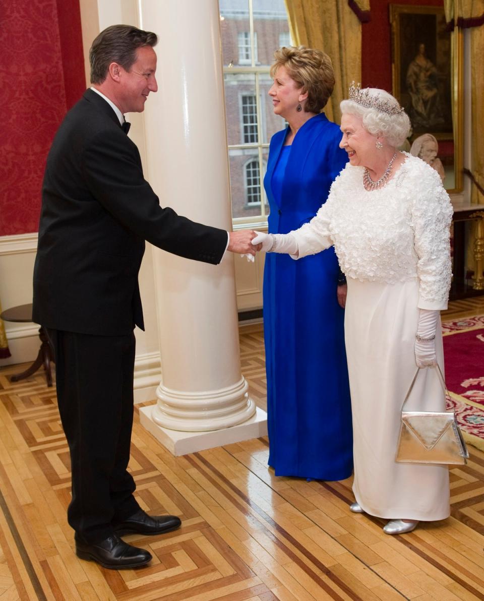 Then Prime Minister David Cameron shakes hands with Queen Elizabeth II as he arrives to attend a state dinner at Dublin Castle (AFP via Getty Images)