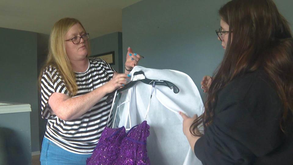 Maggie Long and her mom Debbie unwrap the gown she will be wearing as the lone graduation of St. Mark's School.