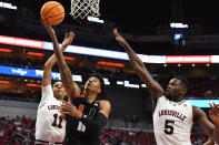 Miami guard Jordan Miller (11) goes in for a layup past Louisville guard Fabio Basili (11) and forward Brandon Huntley-Hatfield (5) during the first half of an NCAA college basketball game in Louisville, Ky., Sunday, Dec. 4, 2022. (AP Photo/Timothy D. Easley)