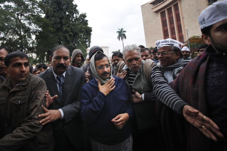 New Delhi Chief Minister Arvind Kejriwal, center, is escorted by supporters and security men during a demonstration against the police in New Delhi, India, Tuesday, Jan. 21, 2014. For a decade, Kejriwal has tilted at India's many windmills. He has led protests and hunger strikes against government corruption.But now he is the top official of the Indian capital, an activist suddenly elevated to power. And just a little over a month after his surprise win in city elections, he has launched yet another protest. Even if it's not always clear what he is demanding. (AP Photo/Altaf Qadri)